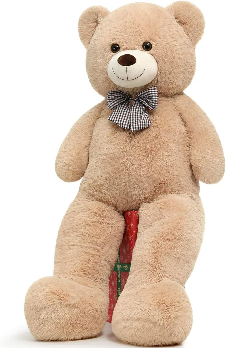Beige teddy bear with a checkered bow tie on a white background