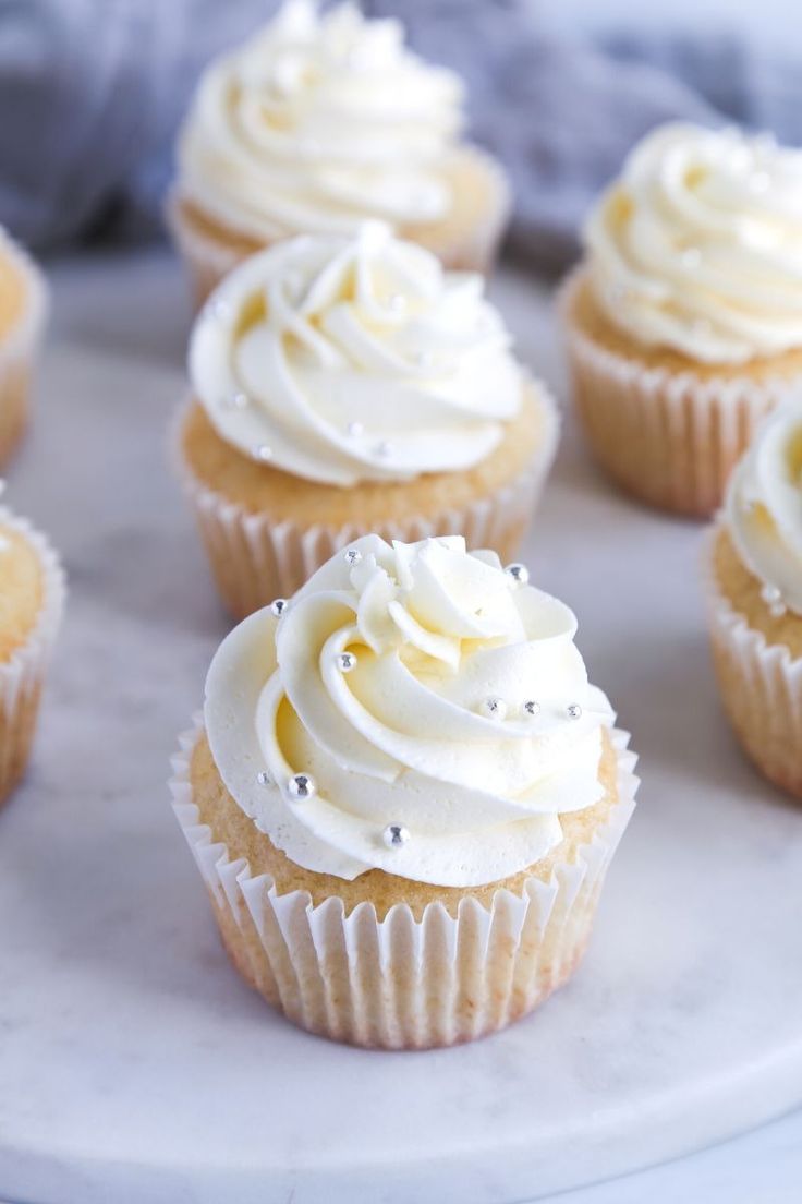 Cupcakes with white frosting on a marble surface